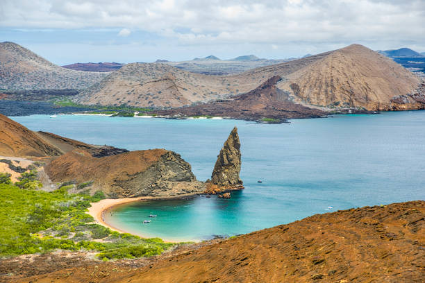 Aerial view of the famous Pinnacle Rock on the small island of Bartolome, Galapagos, Ecuador. In the background is Santiago island.